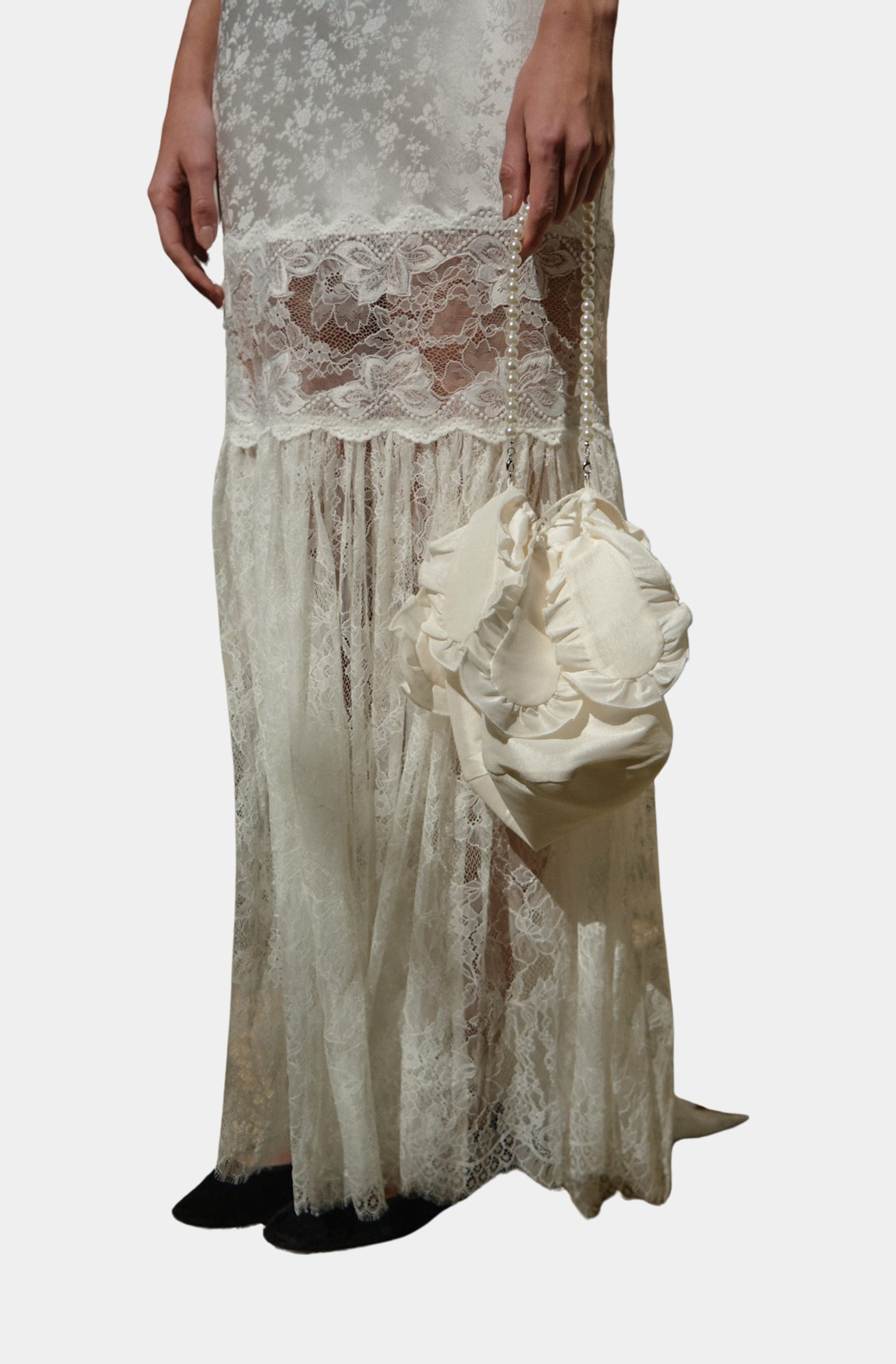 Model holding Cleopatra bridal pouch purse with lace dress